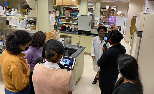 A scientist in a lab being interviewed.